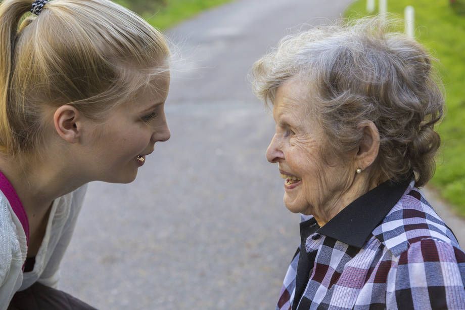 Vanha nainen ja hoitaja keskustelevat ulkona. 