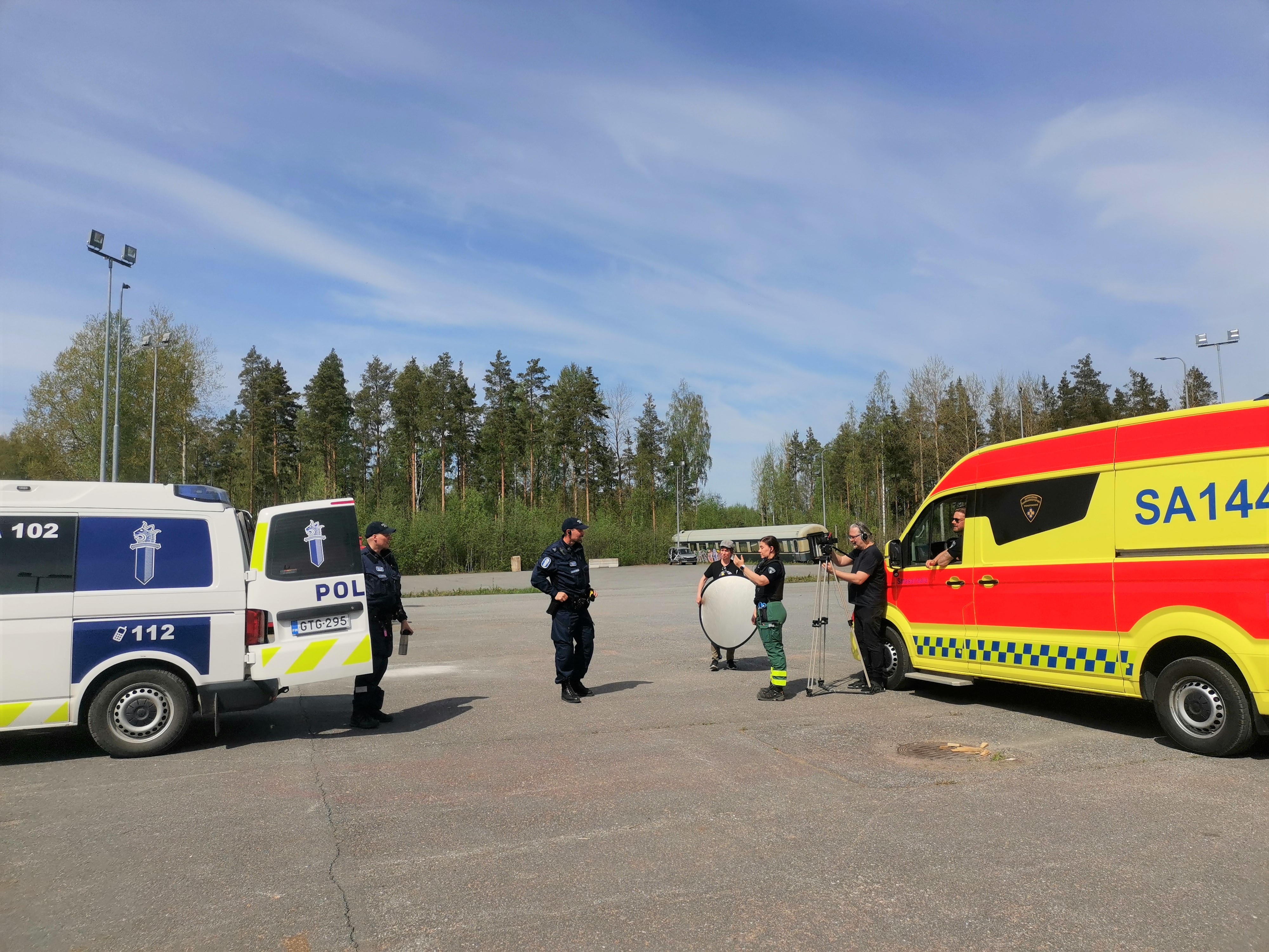 Poliisit ja ensihoidon ammattilaiset kuvaamassa opetusvideota.