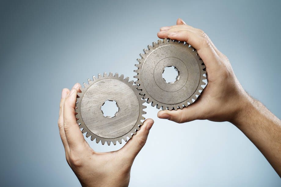 Käsien välissä on kaksi metallista ratasta. 