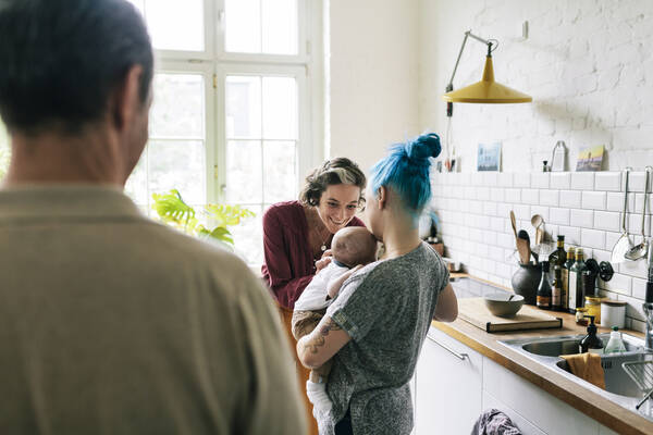 Adults admiring a newborn baby.