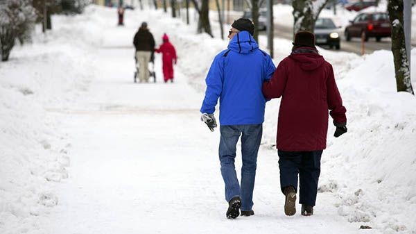Kaksi ihmistä kävelee toisiaan tukien poispäin.