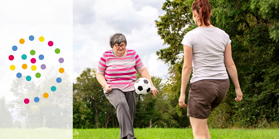 Kaksi henkilöä potkii jalkapalloa.