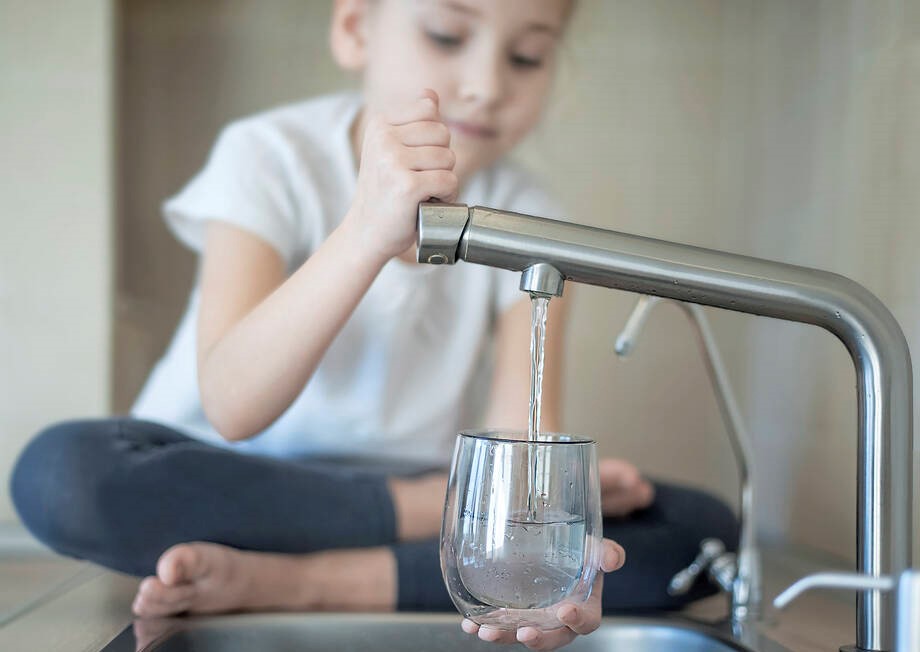 Lapsi ottaa hanasta vettä.