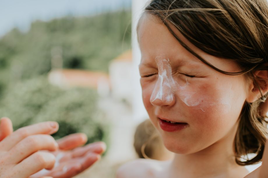 Lapselle laitetaan aurinkorasvaa.