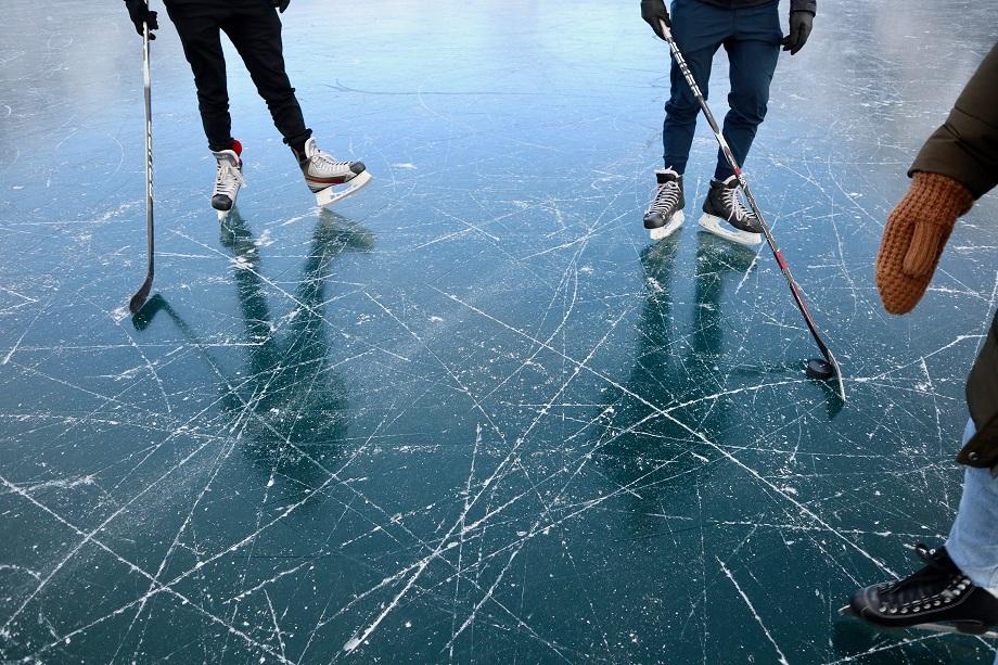 Kolme ihmistä pelaa jääkiekkoa.