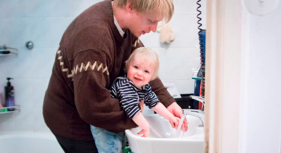 mies ja lapsi pesevät käsiä.