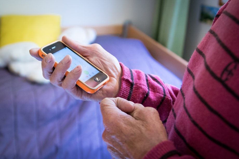 Vanhus käyttää älypuhelinta.