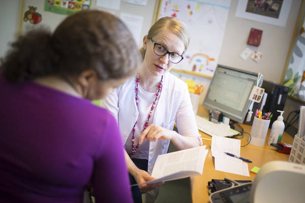 Nainen ja terveydenhoitaja keskustelevat vastaanotolla