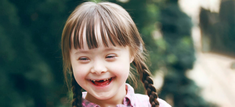 Lettipäinen tyttö nauraa iloisesti.