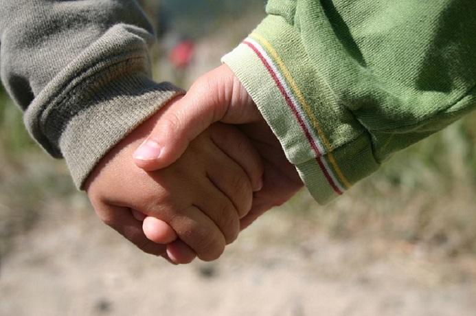 Lapset pitävät toisiaan kädestä.