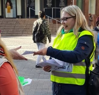 Kehittäjäsosiaalityöntekijä Kaisa Kohvakka jakaa SOSKU-hankkeen esitteitä