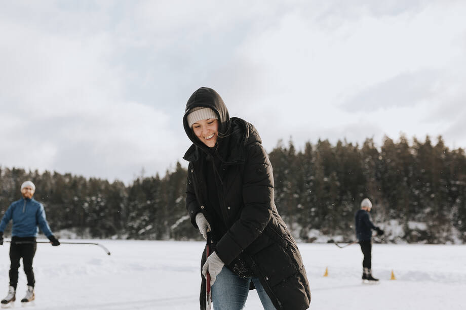 Iloisia ihmisiä pelaamassa jäälätkää.