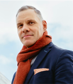 Pasi Lehtimäki hymyilee, taustalla taivas.