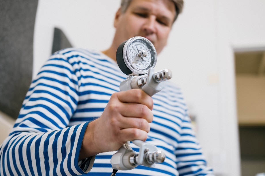 Man with a compression force meter in his hand.