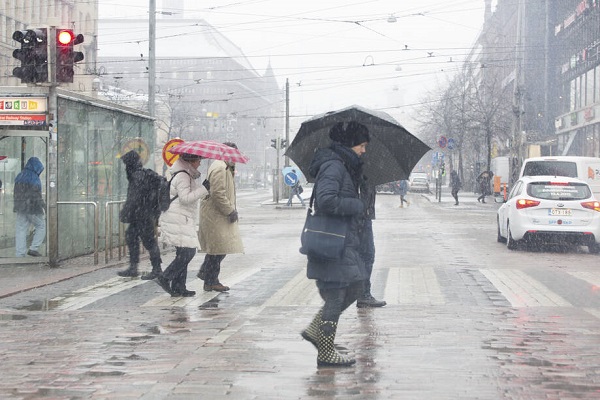 Människor med paraplyer går på gatan.