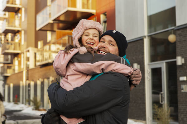 The child is in the father's arms.
