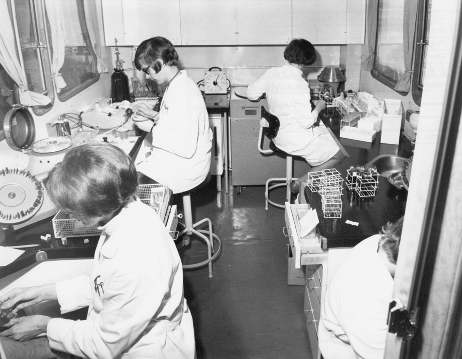 Kuva 12: Laboratorio-osasto toiminnassa Vammalassa 1967. Etualalla laboratorionhoitaja ottamassa verinäytettä- Verinäytteet esikäsiteltiin, jäädytettiin ja pakastettiin paikan päällä. Kaksi kertaa viikossa lähetettiin erä ksekuslaboratorion Helsinkiin.