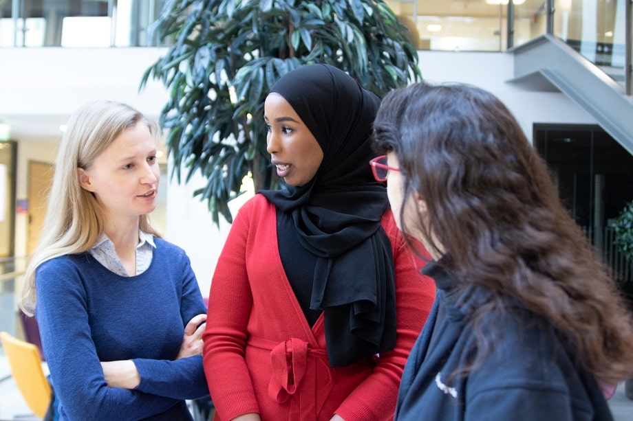 Kolme ammattilaista keskustelee keskenään.