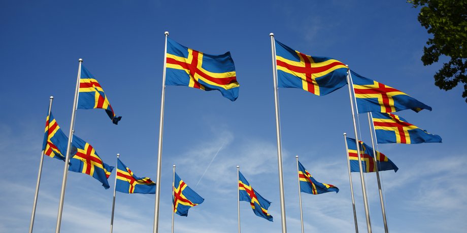 Åländska flaggor som vajar i vinden.