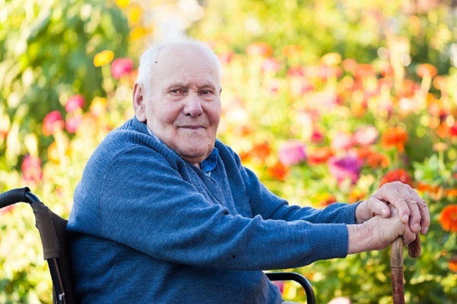 An older man sitting in a wheel chair.