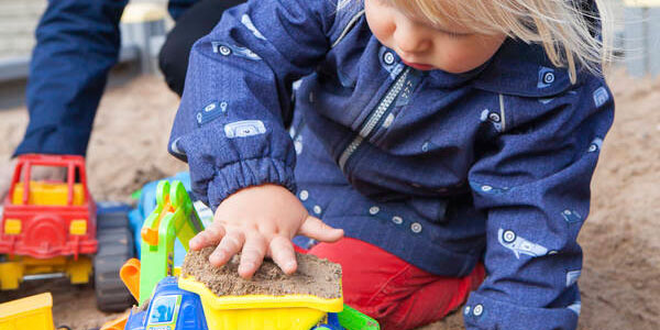 Poika leikkii hiekkalaatikolla.