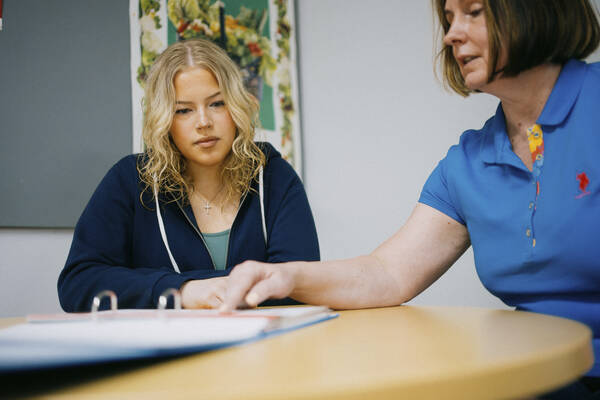 Kaksi henkilöä pöydän ääressä.