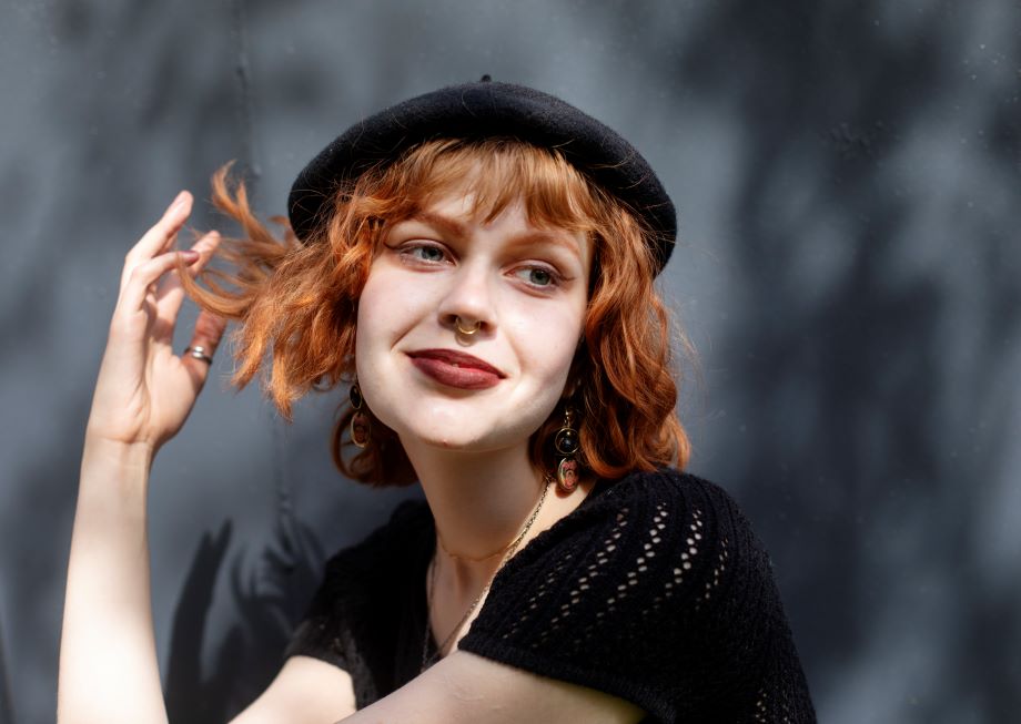 Nuori hymyilee baskeri päässään.