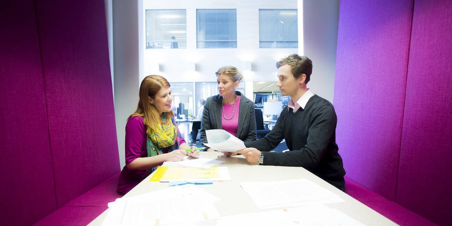 Ihmisiä keskustelemassa työpaikalla.