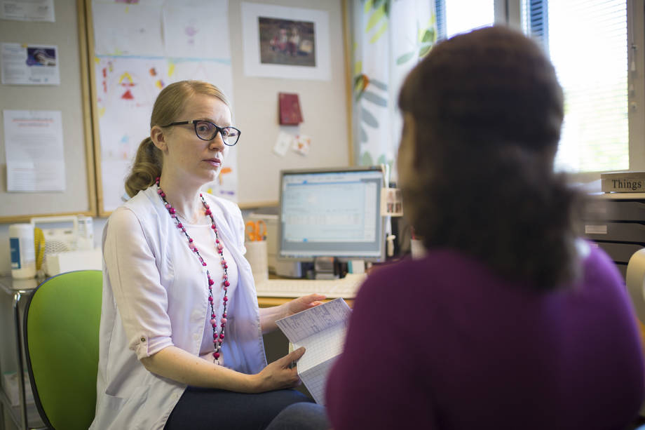 Nainen istuu hoitajan vastaanotolla. 