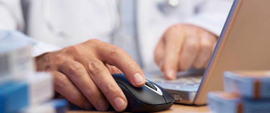 Lääkäri tutkii kannettavalta tietokoneelta tietoja.