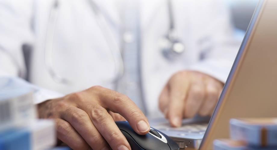 lääkäri tietokoneella.