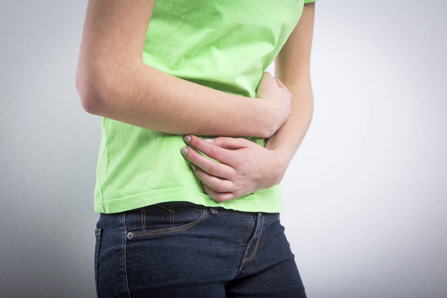 vatsakipu, nainen pitelee vatsaansa.