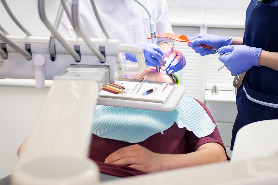Potilas on hammaslääkärin tuolissa operoitavana.