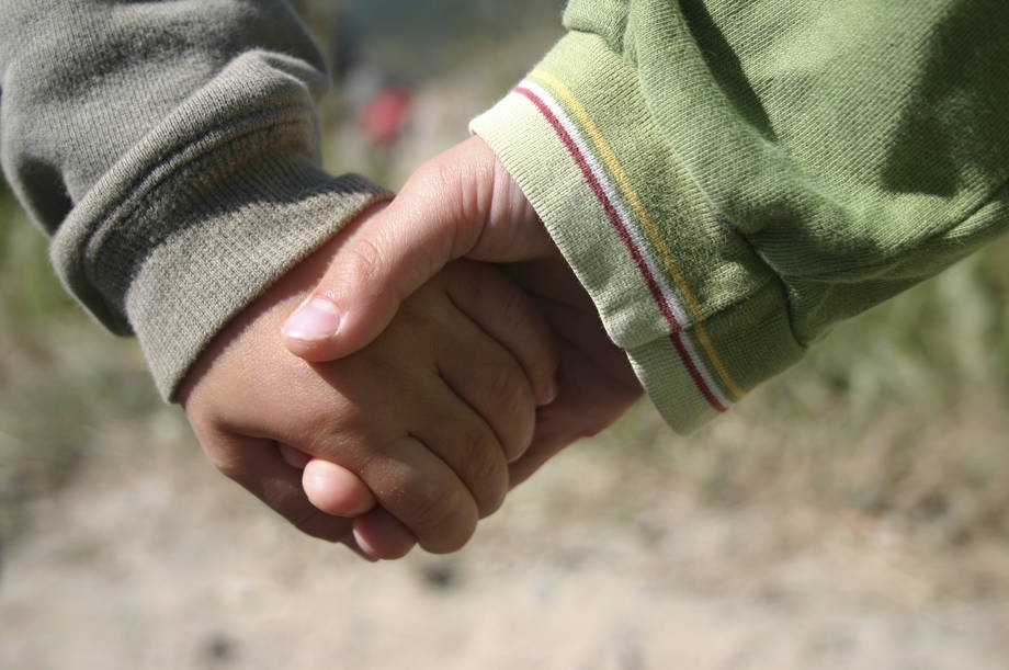 Two children hand in hand.