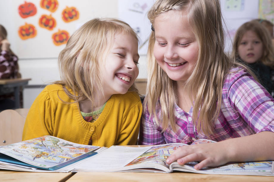 Lapsia istumassa koululuokassa.