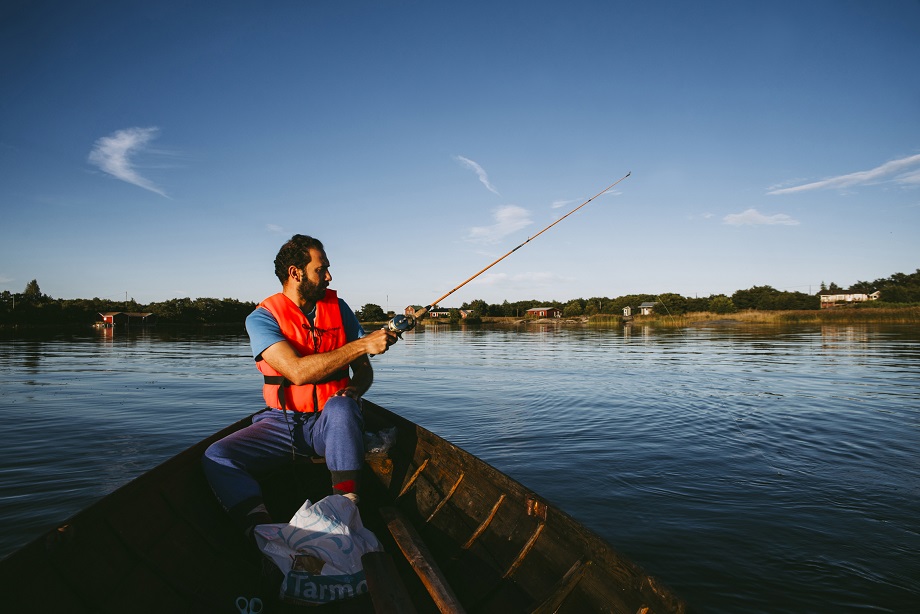 A man is fishing from a boat.
